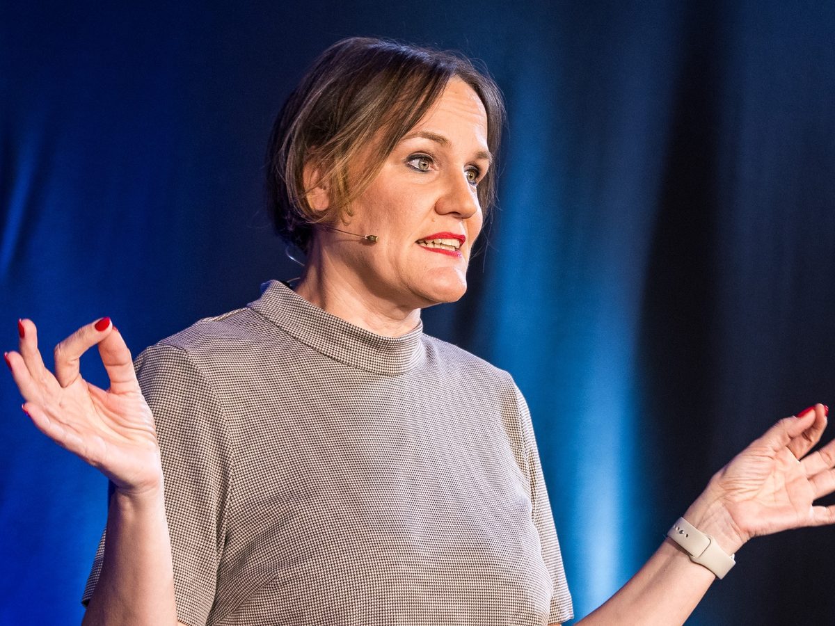 Laura Gintar im Vortrag, Nahaufnahme vor blauer B&uuml;hne